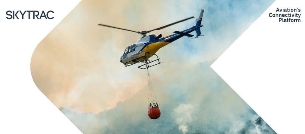 Firefighting helicopter carrying water towards a fire