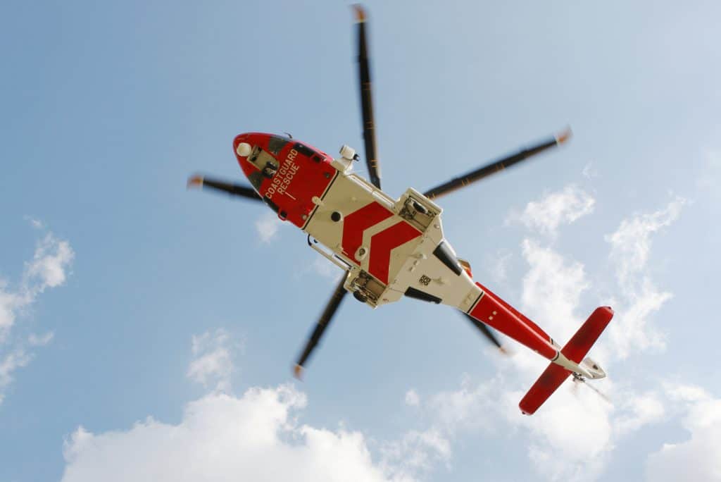 A Coast Guard Rescue helicopter flying.