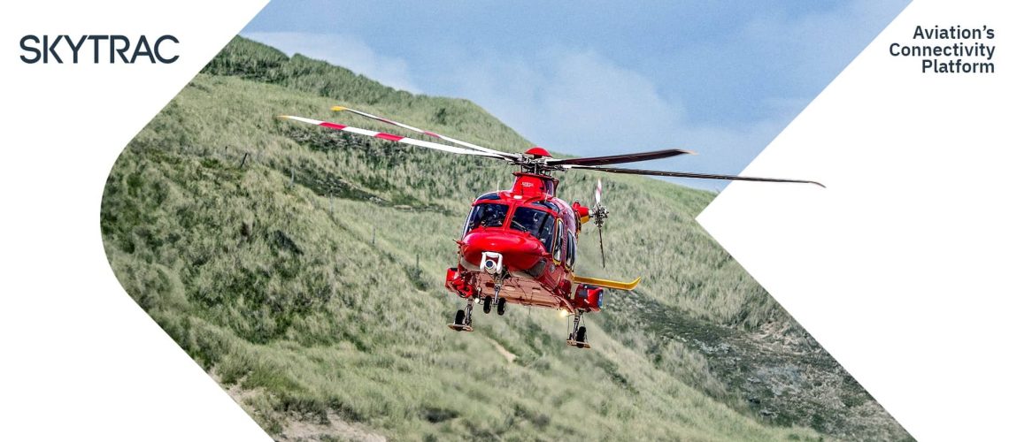 Red helicopter flying near dry mountains